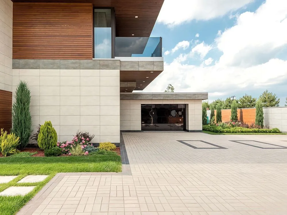 A poured residential concrete driveway leading to a modern home